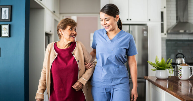 CNA or HHA helping home care patient with walking
